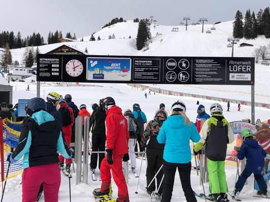 Zugangsportal als Uhrentafel mit Intersport Rent-Sujet im Skigebiet Almenwelt Lofer