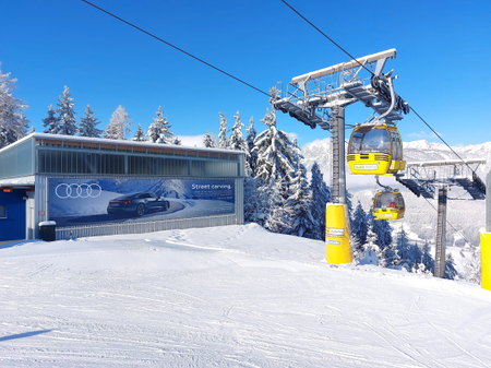 OOH-Werbefläche im Skigebiet Hauser Kaibling in den Alpen: großformatige Audi-Werbung an der Liftstation vor verschneiter Bergkulisse