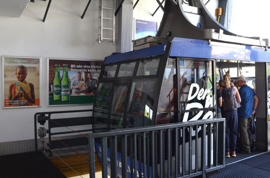 4B Plakat mit Gösser-Sujet und 2B Plakat mit World Vision-Sujet in der Talstation der Vallugabahn, Ski Arlberg, St. Anton am Arlberg