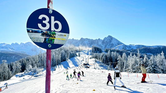 Pistenmarkierung für blaue Piste mit Raiffeisen OÖ-Sujet im Skigebiet Dachstein West