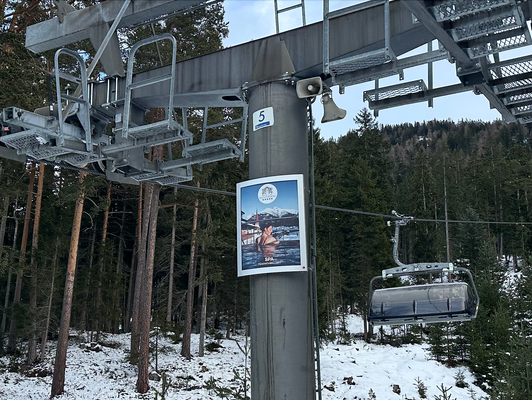 Wellness-Werbung vom Hotel Klosterbräu als Plakat an einer Liftstütze in Seefeld